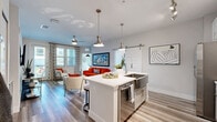 Located in Melbourne, FL, this thoughtfully designed 2-bedroom, 3-bathroom residence offers a single-floor layout that maximizes functionality and style. The open-concept living, dining, and kitchen area forms the heart of the home, featuring wood-look flooring, ceiling fans, and abundant natural light from multiple windows dressed with stylish blinds and patterned curtains. The kitchen stands out with a large center island with seating, white quartz countertops, two-tone gray and white cabinetry, a patterned tile backsplash, stainless steel appliances including a smart refrigerator, a wall-mounted range hood, and industrial-style pendant lighting. A sliding barn door adds a modern farmhouse touch. The living room offers a bright, welcoming atmosphere. Both bedrooms are well-proportioned and light-filled, with the primary bedroom featuring ample closet space. The dedicated office benefits from corner windows, filling the room with natural light — ideal for remote work. Three full bathrooms include a sleek vanity with white countertops and tile accents. Additional highlights include an in-unit laundry room with cabinetry, a pantry, a utility room, a hallway, and a private balcony.