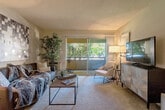 Located at 2086 Lucretia Ave in San Jose, CA, this well-appointed 2-bedroom, 2-bathroom residence offers a thoughtfully designed single-floor layout. The combined living and dining area serves as the heart of the home, with the living room featuring carpet flooring, a textured ceiling, and large sliding glass doors that fill the space with natural light and provide direct access to a private patio overlooking tree-lined surroundings. The dining area is adjacent, finished with wood-style flooring, a ceiling fan, and a warm, intimate atmosphere ideal for everyday meals. The kitchen connects seamlessly to the dining space and includes white appliances. The primary bedroom is generously sized, complete with carpet flooring, a sliding glass door to the patio, and ample natural light. The second bedroom also offers outdoor views and comfortable proportions. Both bathrooms are finished with white vanities and light countertops; one bathroom features convenient in-unit washer access through an adjoining closet. Two dedicated closets provide practical storage throughout. A light-toned, neutral color palette and consistent finishes lend a cohesive and calm ambiance to the entire residence. The layout is efficient and functional, making excellent use of the available space.