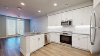 Located at 2332 N 7th St in Phoenix, AZ, this thoughtfully designed single-floor unit offers 1 bedroom and 2 bathrooms within a efficient, well-appointed layout. Light wood-style flooring flows consistently throughout the space, creating a cohesive and clean aesthetic.

The open-concept kitchen and living area serves as the heart of the unit. The kitchen is outfitted with crisp white shaker cabinetry extending to the ceiling, a classic white subway tile backsplash, sleek gray countertops, and a full suite of stainless steel appliances including a refrigerator, range, microwave, and dishwasher. A kitchen island with a built-in sink adds additional prep and counter space.

The living area benefits from a ceiling fan and a set of French doors fitted with blinds, allowing natural light to filter in. The bedroom is a comfortable size, featuring a window with blinds and its own ceiling fan. The primary bathroom connects directly to a well-organized walk-in closet with built-in shelving. Both bathrooms are finished with white subway tile surrounds on the tub/shower, white vanity cabinetry, and gray countertops, maintaining a consistent modern palette throughout the home.