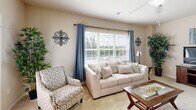 Located at 1461 Jag Branch Blvd in Kernersville, NC, this single-floor residence offers a thoughtfully designed open-concept layout that seamlessly connects the main living areas. The living room is bright and welcoming, featuring large windows dressed with blue drapes and wood blinds that invite generous natural light and outdoor views, complemented by a ceiling fan and plush carpeting. A dedicated workspace area within the living space adds functional versatility.

The kitchen is well-equipped with warm wood cabinetry, granite countertops, a double sink with pendant lighting, tile flooring, and stainless steel appliances including a range and dishwasher. Track lighting overhead enhances both function and ambiance. The adjacent dining area provides a comfortable space for everyday meals, positioned conveniently between the kitchen and living areas.

Both bedrooms are carpeted and feature ceiling fans, ample closet space, and windows that bring in natural light. The primary bedroom includes direct access to an exterior door, while the secondary bedroom offers a walk-in closet. The bathrooms are finished with granite-topped vanities, warm wood cabinetry, and tile flooring. A dedicated laundry room with side-by-side washer and dryer hookups and shelving rounds out this well-organized, comfortable home.