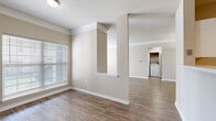 Located at 12001 Horton St in Overland Park, Kansas, this single-story residence offers a well-designed layout with a cohesive neutral color palette throughout. The living area features rich wood-style plank flooring, crown molding, and a tiled fireplace framed by a classic white mantel, creating a warm and inviting focal point. Natural light filters in through blinded windows, enhancing the open feel of the space. A pass-through architectural detail connects the living and dining areas, adding visual interest and an open flow between rooms.

The kitchen is equipped with white cabinetry, a curved breakfast bar, and stainless steel appliances including a refrigerator, microwave, and range. Track lighting overhead adds functional illumination to the workspace. A dedicated in-unit laundry area provides added convenience.

The bedrooms are carpeted for comfort, with each room receiving natural light through large windows. The primary bedroom includes access to an en-suite bathroom featuring a marble-style countertop, a wide vanity mirror, and a walk-in closet with a built-in rod system. A secondary bathroom offers a full vanity with white cabinetry, a large mirror, and a tub-shower combination.
