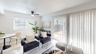 Located in Austin, TX, this single-story, one-bedroom, one-bathroom residence offers a well-planned layout with a clean, modern aesthetic throughout. Light wood-style flooring runs through the main living areas, complementing the crisp white walls and creating a bright, cohesive atmosphere.

The living room is an inviting space anchored by a ceiling fan and large sliding glass doors that flood the room with natural light and open directly to a private outdoor patio. A secondary seating area adjacent to the living room provides additional flexibility for daily living.

The kitchen features white shaker-style cabinetry with matte black hardware, a stainless steel refrigerator, and a single-basin sink beneath a window that brings in additional natural light. The space flows seamlessly into a dedicated dining area, making it practical for everyday use.

The bedroom is a generously sized retreat with plush carpeting, a ceiling fan, and a large window that enhances the sense of openness. A dedicated closet provides ample storage.

The bathroom includes a full tub-shower combination with large-format tile surround and a clean, minimal design. Two hallways connect the spaces efficiently throughout the home, completing this well-appointed and move-in-ready Austin residence.