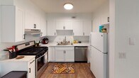 This single-floor residence in Stillwater, Oklahoma, offers a functional and thoughtfully designed living space with consistent, modern finishes throughout. Rich wood-look flooring flows seamlessly across every room, providing a warm and cohesive aesthetic.

The kitchen is a standout feature, showcasing crisp white shaker-style cabinetry with matte black hardware, light-toned countertops, and stainless steel appliances including a gas range and dishwasher. A ceiling-mounted light fixture brightens the space, and ample upper and lower cabinet storage makes the kitchen both practical and visually clean.

The bedroom is a comfortable retreat, featuring a ceiling fan with light, a windowed wall that allows natural light to fill the room, and a textured ceiling. The layout provides generous space for furniture arrangement and everyday living.

The bathroom is well-appointed with a white vanity featuring black hardware, a light countertop with an undermount sink, and a tub-shower combination enclosed by a decorative curtain. The wood-look flooring continues here, tying the room into the home's overall design language.

The floor plan, as seen in the dollhouse view, reveals an efficient layout with well-defined spaces and easy interior flow, making this Stillwater property a practical and comfortable place to call home.