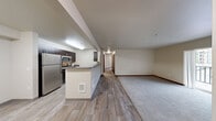 Located in Bothell, WA, this well-appointed 4-bedroom, 2-bathroom unit offers a thoughtfully designed single-floor layout with a practical mix of comfort and functionality. The open-concept kitchen and living area serves as the heart of the home, featuring wood-look plank flooring, dark espresso cabinetry, stainless steel appliances including a refrigerator and microwave, and a peninsula with a grey countertop — ideal for both cooking and casual dining. The living area transitions seamlessly to a private balcony through sliding glass doors, bringing in natural light and outdoor views. The four bedrooms are carpeted and generously sized, with the primary bedroom offering ample space and access to a dedicated walk-in closet equipped with wire shelving. Additional bedrooms feature sliding wood-panel closet doors and windows with exterior views. Both bathrooms are finished with wood-look flooring, dark vanity cabinetry, grey countertops, and full tub/shower combinations. A dedicated carpeted walk-in closet provides extra storage. Neutral wall tones and consistent trim work throughout give the unit a clean, cohesive aesthetic suited for a variety of lifestyles.