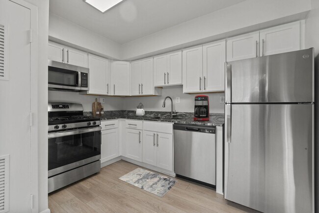 Cocina actualizada con acero inoxidable, cocina a gas y modernos armarios - Rollins Park Apartments