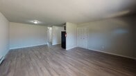 Located at 401 E Gibbsboro Rd in Lindenwold, NJ, this single-floor unit offers a well-organized layout with a clean, neutral aesthetic throughout. The entry opens into a bright living area featuring durable wood-look flooring, baseboard heating, and a front-facing window that draws in natural light. A wall unit air conditioner provides additional climate comfort. The kitchen is a standout feature, appointed with dark espresso shaker-style cabinetry, marble-look countertops with a tile backsplash, a stainless steel sink, and black appliances including a gas range, dishwasher, and refrigerator. A louvered closet door adjacent to the kitchen provides convenient storage access. The bedrooms are carpeted for comfort, each offering baseboard heating and windows with outdoor views of the surrounding community. One bedroom includes dual louvered closets, providing generous storage capacity. The bathroom is finished with a full tub and shower combination, white subway tile surround, and chrome fixtures set against neutral-toned walls and wood-look flooring. Throughout the unit, the light color palette, clean finishes, and functional layout create a comfortable and practical living environment.