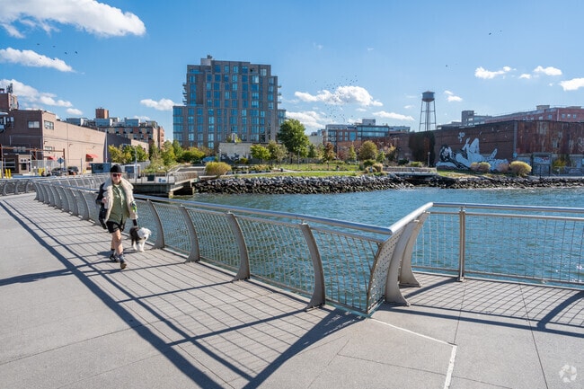 A fella and his dog enjoy a stroll across the bridge at WNYC Transmitter Park in Greenpoint.