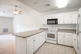Located at 7 Mirror Ln in Moriches, NY, this single-floor residence offers a clean, functional layout designed for comfortable everyday living. The interior is finished throughout in neutral tones, with crisp white walls and light-colored trim that lend a bright, airy feel to the space.

The kitchen is a standout feature, configured in a U-shaped layout with ample white cabinetry providing generous storage. It is equipped with a full suite of appliances including a refrigerator, electric range, microwave, and dishwasher, all set against neutral countertops. Light tile flooring runs through the kitchen and connects seamlessly to the hallway, which provides easy access to the various areas of the home.

The living area is a generously sized, open space with wall-to-wall carpet and a ceiling fan with lighting. A large window allows natural light to fill the room, creating a warm and inviting atmosphere.

The bedrooms are carpeted and well-proportioned, each benefiting from natural light through windows with blinds. One bedroom features a spacious walk-in closet outfitted with wire shelving for organized storage.

The bathroom is neatly appointed with a combination tub and shower enclosed in a sliding glass door, a single-sink vanity with under-cabinet storage, and a large mirror with overhead lighting. The overall ambiance of this home is clean, practical, and move-in ready.