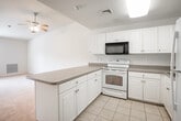 Located at 7 Mirror Ln in Moriches, NY, this single-floor residence offers a clean, functional layout designed for comfortable everyday living. The interior is finished throughout in neutral tones, with crisp white walls and light-colored trim that lend a bright, airy feel to the space.

The kitchen is a standout feature, configured in a U-shaped layout with ample white cabinetry providing generous storage. It is equipped with a full suite of appliances including a refrigerator, electric range, microwave, and dishwasher, all set against neutral countertops. Light tile flooring runs through the kitchen and connects seamlessly to the hallway, which provides easy access to the various areas of the home.

The living area is a generously sized, open space with wall-to-wall carpet and a ceiling fan with lighting. A large window allows natural light to fill the room, creating a warm and inviting atmosphere.

The bedrooms are carpeted and well-proportioned, each benefiting from natural light through windows with blinds. One bedroom features a spacious walk-in closet outfitted with wire shelving for organized storage.

The bathroom is neatly appointed with a combination tub and shower enclosed in a sliding glass door, a single-sink vanity with under-cabinet storage, and a large mirror with overhead lighting. The overall ambiance of this home is clean, practical, and move-in ready.