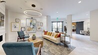 Located at 1000 Fanfare Way in Alpharetta, GA, this single-floor residence offers a clean, modern aesthetic throughout. The open-concept kitchen is a standout feature, showcasing white shaker cabinetry, a classic white subway tile backsplash, quartz countertops, and a peninsula island with an undermount sink. Stainless steel appliances — including a range, microwave, dishwasher, and refrigerator — complete the well-equipped cooking space. Track lighting overhead enhances visibility and adds a contemporary touch. Warm hardwood-style flooring flows through the main living areas, complementing the neutral warm-gray wall tones that create a cohesive, inviting atmosphere. The living area benefits from ample natural light courtesy of large windows with blinds, and is finished with a ceiling fan. A glass-paneled entry door with a transom window above allows additional light into the entryway. Carpeted bedrooms offer comfort and quiet, with generous windows overlooking greenery outside. The primary bathroom includes a white vanity with quartz countertop and direct access to a walk-in closet with wire shelving. Additional utility space with carpeting rounds out the functional layout of this well-designed Alpharetta residence.