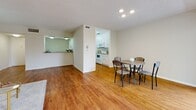 Located at 14400 Addison Street in Sherman Oaks, Los Angeles, this one-bedroom, one-and-a-half-bathroom unit offers a thoughtfully laid-out single-level floor plan with a clean, neutral aesthetic throughout. Warm hardwood-style flooring flows continuously across the living, dining, and bedroom areas, creating a cohesive and inviting atmosphere.

The entry foyer provides a welcoming transition into the main living space, where a bright and open living room features a sliding glass door that opens directly onto a private balcony. The balcony overlooks a lush, landscaped courtyard with mature palm trees and tropical greenery, offering a serene outdoor retreat.

The dining area sits adjacent to the living room and connects seamlessly to the kitchen, which features white cabinetry, granite-style countertops, a double-basin sink, and white appliances including a dishwasher, range, and microwave. A pass-through counter further enhances the open flow between the kitchen and dining space.

The spacious bedroom is lined with dual sliding-door closets, providing generous storage. The full bathroom includes a tub-shower combination with glass sliding doors, a wide vanity with stone-style countertops, and a large mirror. A half bathroom with a dedicated vanity area adds convenience for guests. Textured ceilings are present throughout the unit.