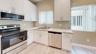 Located at 7731 Trask Ave in Westminster, California, this single-story property offers a clean, modern aesthetic throughout its thoughtfully designed layout. Light wood-look flooring flows seamlessly across every room, creating a bright and cohesive atmosphere.

The open kitchen is a standout feature, showcasing white shaker cabinetry with brushed nickel hardware, speckled granite countertops, and a subway tile backsplash. Stainless steel appliances — including a range, microwave, and dishwasher — complement the crisp white finishes. Multiple windows with vertical blinds allow natural light to fill the space, enhancing the airy feel of the combined kitchen and living area.

The living area is generously sized and open, equipped with a wall-mounted mini-split HVAC unit for efficient climate control. Additional rooms include well-proportioned bedrooms, one featuring a ceiling fan, and a dedicated cabinetry nook with granite countertops offering ample built-in storage.

The bathroom is finished with large-format tile surrounding the tub-shower combo, light wood-look flooring, a white vanity with granite countertop, and a frameless mirror — maintaining the consistent, updated style found throughout the home. Recessed lighting adds a polished touch to the overall interior design.