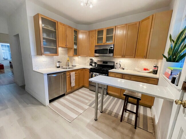 Quartz countertops, breakfast bar stainless-steel refrigerator, oven range, dishwashasher, microwave - 2723 W Agatite Ave