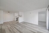 Located at 561 West San Ysidro Boulevard in San Diego, CA, this single-floor, 3-bedroom, 2-bathroom home offers a clean, modern aesthetic throughout. The combined dining and living area is an open, airy space finished with light-toned luxury vinyl plank flooring and a textured ceiling, anchored by a ceiling fan and filled with natural light from a sliding glass door that opens to a private patio. The kitchen is thoughtfully designed with white shaker cabinets, quartz countertops, recessed lighting, and stainless steel appliances including a refrigerator, range, and dishwasher. The galley-style layout maximizes efficiency while maintaining a bright, contemporary feel. The three bedrooms feature plush carpeting and windows with blinds that invite natural light. The primary bedroom offers a comfortable footprint with ample closet space. Both bathrooms are finished in a crisp, all-white palette; one includes a tub-shower combo with a lighted vanity mirror, while the other features a walk-in shower. Additional highlights include an in-unit laundry area and a wall-mounted A/C unit. The overall design is cohesive and neutral, making for a move-in-ready home in the heart of San Diego.