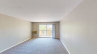 Located at 235 Camelback Rd in Pleasant Hill, California, this second-floor apartment presents a clean, functional layout across a single level. The spacious living room is finished with plush wall-to-wall carpeting in a neutral tone and features a sliding glass door that opens onto a private balcony, allowing abundant natural light and pleasant views of the surrounding greenery. A wall-mounted air conditioning unit ensures year-round comfort in this main living area.

The kitchen is outfitted with crisp white cabinetry featuring brushed nickel hardware, generous countertop space with a neutral gray surface, and a full suite of appliances including a range and refrigerator. The layout provides ample storage and a practical workspace for everyday cooking.

The bedrooms continue the neutral color palette with soft carpeted floors and large windows that draw in natural light and views of the exterior landscaping. The rooms offer generous wall space and a tranquil ambiance suited for rest and relaxation.

The bathroom is well-appointed with a wide vanity topped with a gray countertop, an undermount sink, brushed nickel fixtures, and a large mirror with stylish pendant lighting overhead. Clean white cabinetry below provides ample storage. Throughout the unit, neutral walls, white trim, and consistent finishes contribute to a cohesive, move-in-ready aesthetic.