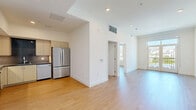Located at 1233 N Highland Ave in the heart of Los Angeles, this modern 2-bedroom, 2-bathroom unit offers a clean, contemporary design throughout. Light-toned hardwood flooring runs seamlessly across every room, lending warmth and continuity to the open layout. The living area is bright and airy, with recessed lighting and easy flow to the rest of the unit. The kitchen is well-appointed with light wood cabinetry, dark countertops, a tasteful tile backsplash, and a full suite of stainless steel appliances including a French-door refrigerator and dishwasher. Both bedrooms are comfortably sized, featuring large windows that frame striking views of the surrounding Los Angeles cityscape and the Hollywood Hills beyond, filling each room with abundant natural light. The unit includes four closets, providing generous storage throughout. Both bathrooms are finished with large-format tile surrounds in the tub-shower combinations and light wood vanities with dark countertops. A stacked in-unit washer and dryer is neatly tucked into a dedicated laundry closet, adding everyday convenience. The overall ambiance is modern and move-in ready, reflecting a cohesive, minimalist aesthetic well-suited to urban Los Angeles living.