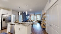 Located in Jacksonville, FL, this thoughtfully designed 2-bedroom, 2-bathroom residence offers a cohesive blend of modern finishes and comfortable living across a single floor. The open living room is anchored by large windows and a glass-paneled door that floods the space with natural light and provides views of the lush surroundings. A ceiling fan adds a practical touch, while wood-look flooring flows throughout, tying the spaces together seamlessly. The kitchen is a standout feature, outfitted with crisp white shaker cabinetry extending to the ceiling, a classic subway tile backsplash, granite countertops, stainless steel appliances, and an island that provides additional prep and dining space. The primary bedroom is generously proportioned, bathed in natural light from large windows, and includes a dedicated walk-in closet. The second bedroom is equally inviting, offering ample space, a ceiling fan, and bright window views. Both bathrooms are finished with granite-top white vanities, wood-look flooring, and white cabinetry offering generous storage. The primary bath features a walk-through layout leading directly to the walk-in closet. Each room reflects a clean, contemporary aesthetic with a warm, livable ambiance throughout.