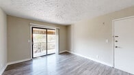 Located at 4601 Packard Drive in Nashville, TN, this 2-bedroom, 3-bathroom unit offers a practical and comfortable single-floor layout. The open living room features light gray wood-look flooring, neutral beige walls, a textured ceiling, and a sliding glass door that opens onto a private balcony with outdoor views of surrounding greenery. The kitchen is well-appointed with white cabinetry, granite-style laminate countertops, a double stainless steel sink, and black appliances including a refrigerator, range, microwave, and dishwasher, all set on matching wood-look flooring. Both bedrooms are carpeted and offer a calm, neutral palette; the primary bedroom is generously sized with a sliding closet, while the second bedroom includes a ceiling fan and a window with natural light. Three bathrooms serve the unit, including a clean, tiled bath with a full soaking tub and a separate half bath with a pedestal-style vanity and framed mirror. A hallway connects the sleeping quarters and bathrooms, providing functional separation between living and private spaces. The textured ceilings and consistent neutral tones throughout create a cohesive, move-in-ready aesthetic.