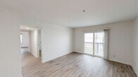 This single-floor, 3-bedroom, 1-bathroom unit offers a clean and functional layout with modern finishes throughout. The exterior features a balcony with a blue railing that looks out over swaying palm trees directly toward the beach and ocean — a standout feature that sets a distinctive coastal tone.

Inside, the galley-style kitchen is equipped with stainless steel appliances, including an electric range, and is finished with white cabinetry and marble-look countertops. Light ceramic tile flooring runs through the kitchen and connects to the hallway, which links the main living areas efficiently.

The three bedrooms are finished with light wood-look luxury vinyl plank flooring and crisp white walls, creating a bright and neutral atmosphere. The spacious primary bedroom offers generous room to furnish comfortably, while the two secondary bedrooms each include closets and windows that bring in natural light. All bedrooms maintain a clean, minimalist aesthetic with doors featuring modern hardware.

The bathroom includes a full tub-and-shower combination with a clean white surround. Central HVAC vents are present throughout the unit, ensuring year-round comfort.

The surrounding grounds include a landscaped lawn with mature palm trees, a parking area, and direct proximity to the beachfront — making this a compelling coastal living opportunity.
