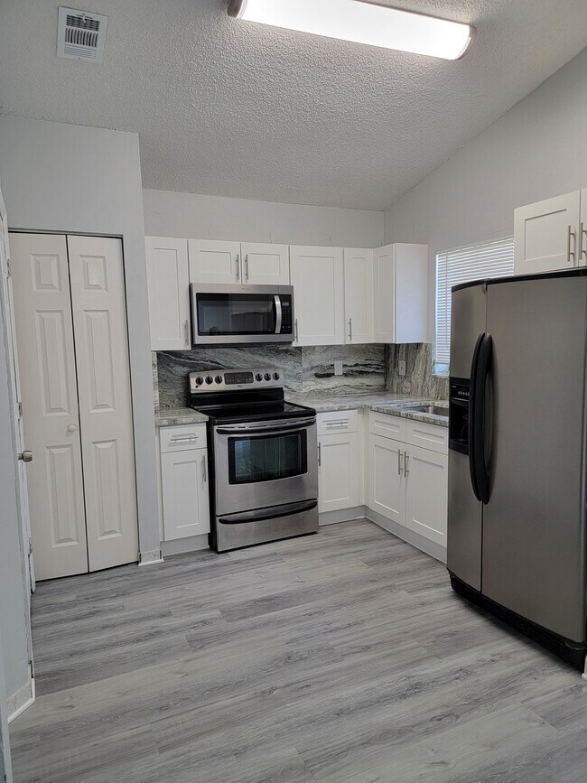 Cocina completamente renovada con gabinetes nuevos, encimeras de granito, electrodomésticos de acero inoxidable. - 3621 NW 193rd St