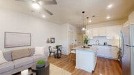 This thoughtfully designed 1-bedroom, 1-bathroom residence offers an efficient and functional layout across a single floor. The open-concept living and kitchen area serves as the heart of the home, featuring warm hardwood-style flooring, recessed lighting, and ceiling fans that enhance the bright, airy atmosphere. The kitchen is a standout, boasting white shaker cabinetry, granite countertops, a classic subway tile backsplash, stainless steel appliances including a refrigerator, range, and microwave, and a central island with pendant lighting — ideal for both meal prep and casual dining. The living area flows seamlessly into a dedicated dining space, creating a versatile environment for everyday living. The bedroom is a comfortable retreat, complete with a ceiling fan, ample natural light, and access to two closets for generous storage. The bathroom is well-appointed with a granite-topped vanity, white cabinetry, and a full soaking tub with shower. Additional conveniences include a dedicated laundry area and two closets throughout the unit. Clean white walls, consistent flooring, and modern finishes throughout create a cohesive and contemporary aesthetic.