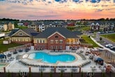 This well-appointed 830-square-foot, single-floor unit offers 1 bedroom and 1 bathroom with a thoughtfully designed layout. The open-concept kitchen and living area serves as the heart of the home, featuring hardwood-style plank flooring, crown molding, and large windows with blinds that invite natural light. A pendant-lit breakfast bar with granite countertops connects the living space to the kitchen, which is equipped with dark espresso shaker cabinets, granite countertops, and a full suite of stainless steel appliances, including a range, microwave, and dishwasher. The spacious 200-square-foot primary bedroom is fitted with plush wall-to-wall carpeting, a ceiling fan, and generous closet access. The bathroom features a granite-topped vanity with dark wood cabinetry, a framed mirror, tile flooring, and a walk-in shower. A dedicated laundry room houses a full-size washer and dryer alongside upper cabinetry for added storage. Crown molding, ceiling fans throughout, and a consistent neutral color palette create a cohesive, clean aesthetic across the entire unit.