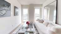Located at 265 Boulevard Brunswick in Pointe-Claire, this well-appointed unit offers a thoughtfully designed layout comprising a kitchen, living room, bedroom, office, and bathroom on a single floor. The galley-style kitchen is outfitted with stainless steel appliances, two-tone cabinetry in white and warm wood, a light quartz countertop, and a subway tile backsplash. A peninsula with additional storage extends into the open area, enhancing both functionality and flow. The living room is bright and airy, benefiting from multiple windows that frame outdoor views and fill the space with natural light. Clean white walls provide a neutral backdrop, complemented by light wood-style flooring throughout. The dedicated office features a window with an outdoor view, offering a comfortable and functional workspace. The primary bedroom is a calm retreat with a built-in closet and natural light from a window. The bathroom is finished with large-format marble-look tile flooring, a tiled tub-shower surround, and recessed lighting. In-unit stacked laundry is conveniently tucked within a dedicated closet. The overall aesthetic is modern and minimal, with a cohesive palette of neutral tones and contemporary finishes throughout.