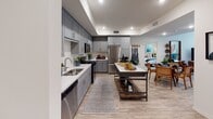 Located at 5377 Quail Run Rd in Riverside, California, this single-story residence offers a well-designed layout with a cohesive, contemporary aesthetic throughout. The kitchen is a standout feature, showcasing gray shaker-style cabinetry, white quartz countertops, a full suite of stainless steel appliances including a gas range and refrigerator, and wood-look flooring that extends throughout the main living areas. A central island provides additional prep and dining space, while recessed lighting creates a bright, functional atmosphere.

The living room is warm and welcoming, featuring large windows dressed with blinds and patterned curtains that allow natural light to fill the space. The bedrooms are comfortably appointed with plush carpeting and ceiling fans. The primary bedroom includes a tray ceiling detail and a window with views of lush greenery outside. A secondary bedroom is versatile, currently configured with bunk beds, and is well-lit by multiple windows.

The bathrooms are finished with wood-look flooring, gray vanity cabinetry, white countertops, and tub-shower combinations with clean tile surrounds. Throughout the home, a consistent neutral color palette accented with warm and cool tones creates a cohesive and inviting living environment.