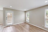 Located at 2200 Montgomery Park Blvd in Conroe, TX, this single-floor one-bedroom residence offers a thoughtfully designed layout that maximizes comfort and functionality. The open-concept living and kitchen area is anchored by light-toned luxury vinyl plank flooring, neutral warm-beige walls, and recessed lighting, creating a bright and welcoming atmosphere. Multiple windows fitted with white blinds invite generous natural light throughout the main living space, which also features a private entry door.

The kitchen is well-equipped with gray shaker-style cabinetry, quartz countertops, and stainless steel appliances including an electric range and dishwasher. A pass-through opening connects the kitchen to the living area, reinforcing the open feel of the floor plan.

The bedroom is a comfortable retreat finished with plush carpeting, a ceiling fan with light fixture, and a window overlooking the surrounding landscape. An adjacent walk-in closet provides ample storage with dual hanging rods and a shelving system, all finished with clean white walls and matching carpet underfoot.

The overall design aesthetic is clean and contemporary, with a consistent neutral palette, white trim work, and modern fixtures that lend a cohesive, move-in-ready appeal to this Conroe residence.