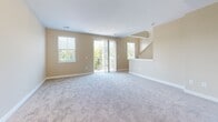 Located at 950 Charlottes Ln in Owings Mills, MD, this three-bedroom, three-bathroom townhome spans three well-organized floors. The ground level provides a private attached garage with automatic opener, offering convenient and secure parking. The main living floor features an open-concept kitchen and living room, where plank-style flooring runs through the kitchen, complemented by rich cherry cabinetry, granite countertops, a stainless steel appliance suite including a range, microwave, and dishwasher, and a deep undermount sink. The adjacent living area is carpeted and filled with natural light through multiple windows and sliding glass doors that lead to an outdoor balcony with views of surrounding greenery. The uppermost floor hosts all three bedrooms, each finished with soft carpet and generous closet space, including walk-in closets with wire shelving systems. The spacious primary bedroom provides ample room for a full furniture arrangement. Three full bathrooms feature tile flooring, granite-topped vanities with rich wood cabinetry, and either a tub-shower combination or a standalone walk-in glass shower. Neutral warm-toned walls and consistent finishes throughout create a clean, cohesive aesthetic across this well-appointed multi-level home.