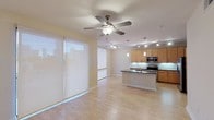 Located along the vibrant South Lamar Boulevard corridor in Austin, Texas, this single-floor unit offers a clean, contemporary design with an open-concept layout that seamlessly connects the living area and kitchen. Light wood flooring runs throughout, contributing to a bright and cohesive aesthetic.

The living area is anchored by a ceiling fan and benefits from abundant natural light streaming through large windows fitted with sleek roller shades. The open sightlines to the kitchen create a spacious, airy feel well-suited to everyday living and entertaining.

The kitchen is thoughtfully designed with warm maple cabinetry, dark granite countertops, and a white subway tile backsplash. A central island with a double stainless steel sink serves as both a functional workspace and a visual focal point. Stainless steel appliances, including a range, microwave, and refrigerator, complement the modern aesthetic. Pendant lighting and a track lighting system provide layered illumination throughout the space.

Additional highlights include a walk-in closet with built-in shelving and rod systems, offering practical and well-organized storage. The overall ambiance is modern and understated, with neutral tones and consistent finishes creating a polished, move-in-ready environment in one of Austin's most sought-after neighborhoods.