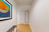 Located at 605 Concord Ave in Cambridge, MA, this thoughtfully designed two-bedroom, two-bathroom residence offers a bright and contemporary living experience across a single floor. The open-concept layout is anchored by a spacious living area bathed in natural light through expansive floor-to-ceiling windows that frame lush tree-lined views, creating a seamless connection between indoors and the surrounding greenery. Track lighting and light hardwood flooring run throughout, lending a clean, modern aesthetic.

The kitchen features white cabinetry, a tile backsplash, stainless steel appliances, and a generous peninsula with bar seating — ideal for both everyday living and casual entertaining. A welcoming entryway with a built-in closet leads deeper into the residence.

The primary bedroom is a well-proportioned retreat with large windows overlooking mature trees, complemented by an en-suite bathroom and an organized walk-in closet with built-in shelving. The second bedroom also enjoys ample natural light with exterior views. Both bathrooms are finished in a clean, modern style with white vanities and contemporary fixtures.

Additional features include in-unit laundry, three closets providing excellent storage, and a layout that balances comfort and functionality throughout.