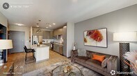 Located at 905 W Main St in the heart of Durham, NC, this one-bedroom, one-bathroom residence offers a thoughtfully designed open-concept layout finished with light wood-style flooring throughout. The kitchen serves as a central hub, showcasing sleek gray flat-front cabinetry, a classic white subway tile backsplash, stainless steel appliances, and a spacious white quartz island with seating for two — illuminated by industrial-style pendant lights. The kitchen flows seamlessly into the living room, where large windows with plantation shutters allow abundant natural light and provide a welcoming ambiance. The bedroom features a striking navy accent wall, ceiling fan, and generous windows that continue the theme of natural light. A dedicated closet with built-in shelving and hanging storage connects directly to the bathroom, which includes a tiled walk-in shower and wood-style flooring. Additional conveniences include a utility room and in-unit laundry. The space is efficiently organized across a single floor, making it ideal for comfortable urban living in one of Durham's most vibrant neighborhoods.