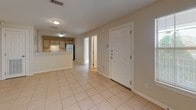 This single-floor residence offers a clean, functional layout with a warm, neutral color palette throughout. The entryway opens into a spacious living and dining area finished with light ceramic tile flooring, providing a bright and airy feel. A ceiling fan adds comfort to the main living space, which flows seamlessly toward the kitchen.

The kitchen is equipped with light wood cabinetry offering ample storage, a white electric range with overhead ventilation, a full-size refrigerator, and a double sink. The tile flooring continues throughout the kitchen, maintaining a cohesive look with the main living area.

The bedrooms are carpeted and generously sized, each featuring ceiling fans with integrated lighting and windows fitted with blinds that allow for natural light while maintaining privacy. One bedroom includes an en-suite bathroom, adding convenience and functionality.

The bathroom is well-appointed with a full tub-shower combination, a single-sink vanity with light wood cabinetry, an overhead medicine cabinet with mirror, and tile flooring that complements the rest of the home. The overall design is practical and straightforward, with consistent finishes and a neutral tone that offers a versatile canvas for personalization.