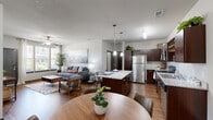Located at 1419 Cycle Heights in Colorado Springs, CO, this 2-bedroom, 2-bathroom single-story home offers a well-designed open-concept layout. The combined kitchen and living room serves as the heart of the space, featuring rich dark wood cabinetry, granite countertops, a central island with bar seating, stainless steel appliances, and pendant lighting overhead. The living area flows naturally from the kitchen and is brightened by natural light from front-facing windows, complemented by a ceiling fan above. Hardwood-style flooring runs throughout the main living areas, adding warmth and continuity to the design. The primary bedroom offers a comfortable, carpeted retreat with a large window that brings in ample natural light and a ceiling fan for added comfort. The second bedroom is equally well-appointed. Both bathrooms include granite-topped vanities, dark wood cabinetry, and tub-shower combinations with hardwood-style flooring. A dedicated in-unit laundry area houses a full-size washer and dryer alongside a water heater. The attached garage provides generous storage and parking space. Each bedroom benefits from its own closet, rounding out the functional and practical layout of this Colorado Springs home.