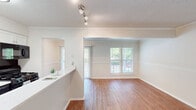Located at 3020 Spanish Ct in Raleigh, NC, this single-floor, 2-bedroom, 2-bathroom residence offers a well-organized layout with a thoughtful mix of finishes and functional living spaces. The open living and dining area features warm hardwood-style flooring, crown molding, a textured ceiling, and multiple windows that invite natural light and views of the surrounding greenery. A pass-through peninsula connects the kitchen to the main living space, creating an open and connected feel. The kitchen is equipped with white shaker cabinetry, light countertops, a gas range, built-in microwave, and black refrigerator, all complemented by hardwood-style flooring. Both bedrooms are carpeted and include ceiling fans with light fixtures and windows overlooking the exterior. The primary bedroom features two closets, including a dedicated walk-in closet outfitted with wire shelving systems on both sides for ample storage. Both bathrooms offer tub-shower combinations with updated fixtures and hardwood-style flooring. A hallway connects the bedrooms and bathrooms, completing a practical and cohesive floor plan suited for comfortable everyday living.
