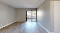 Located at 6565 W Bethany Home Rd in Glendale, AZ, this single-floor 2-bedroom, 1-bathroom residence offers a clean, modern aesthetic throughout. Wood-look plank flooring runs consistently across the living areas, bedrooms, and bathroom, lending a cohesive and contemporary feel to the entire space.

The combined kitchen and living room area serves as the heart of the home. The kitchen is well-equipped with white shaker cabinets, quartz-style countertops, a grey subway tile backsplash, stainless steel appliances including a refrigerator and dishwasher, and a peninsula breakfast bar that opens toward the living area. The living room receives ample natural light through a sliding glass door that leads to a private balcony with outdoor views.

Both bedrooms feature neutral warm-grey walls, wood-look flooring, textured ceilings, and windows that bring in natural light. The primary bedroom includes a sliding closet for storage, while the second bedroom is served by a dedicated hallway closet. A connecting hallway links the bedrooms to the shared bathroom.

The bathroom is finished with a white vanity, single-basin sink, and a full tub-shower combination with a curved chrome curtain rod, all complemented by the same wood-look flooring. Clean white trim and neutral tones throughout the residence create a bright, move-in ready environment.