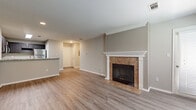 Located at 27701 Detroit Road in Westlake, Ohio, this single-floor, one-bedroom, one-bathroom residence offers a thoughtfully laid-out and well-appointed living environment. The open living room serves as the heart of the home, featuring wood-look plank flooring, neutral gray walls, and a standout fireplace with a classic white mantle and warm tile surround — an inviting focal point for the space. Natural light filters in through multiple windows fitted with blinds, creating a bright and comfortable atmosphere throughout.

The kitchen is efficiently designed with rich, dark wood cabinetry accented by brushed nickel hardware, stone-look countertops, and stainless steel appliances including an electric range and over-the-range microwave. A peninsula counter connects the kitchen to the living area, enhancing the open feel.

The bedroom is generously sized, finished with plush carpet, a ceiling fan, and a window that brings in natural light. A wide sliding-door closet provides ample built-in storage with wire shelving.

The bathroom is clean and functional, featuring a dark wood vanity with a stone-look countertop, a large mirror, tile-surround shower/tub combination with a classic blue accent tile detail, and wood-look flooring. This residence combines practical design with updated finishes throughout.