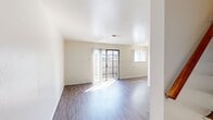 Located in the Bay Terrace community of San Mateo, CA, this two-story apartment offers 700 square feet of living space spread equally across two floors of 350 square feet each. The unit features 2 bedrooms, 1 bathroom, a dedicated kitchen, a staircase connecting both levels, and two closets for ample storage.

The living area on the lower floor is bright and open, with wood-style flooring, neutral cream walls, and a sliding glass door that invites abundant natural light and provides access to an outdoor balcony area. The galley-style kitchen is efficiently designed with white cabinetry lining both walls, light countertops, a stainless steel refrigerator, and a gas range, complemented by the same wood-style flooring throughout.

Upstairs, both bedrooms continue the clean, neutral aesthetic with wood-style floors and white walls. The primary bedroom measures 130 square feet and features a window with exterior views and a closet. The second bedroom includes a sliding mirror closet door and a large window with vertical blinds, filling the room with natural light. The shared bathroom is finished with white tile surrounding a full soaking tub and shower combination, with a small window for ventilation and natural light.