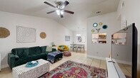 This single-story, 3-bedroom, 2-bathroom home offers a well-organized layout designed for comfortable everyday living. The living room serves as the heart of the home, featuring striking vaulted ceilings, light-toned tile flooring, and a ceiling fan that enhances the sense of openness and airflow. Large windows allow natural light to pour in, creating a bright and welcoming atmosphere. The living area flows seamlessly into the dining space, which is anchored by a pendant light fixture and leads directly into the kitchen.

The galley-style kitchen is efficiently designed with white cabinetry, granite-look countertops, and stainless steel appliances, including a range, microwave, refrigerator, and dishwasher — providing everything needed for day-to-day meal preparation.

The three bedrooms are carpeted for warmth and comfort, each equipped with a ceiling fan. The primary bedroom offers a generous footprint with a closet, while the secondary bedrooms are well-sized and filled with natural light from their windows. All three rooms share a quiet, residential feel.

Both bathrooms are finished with large-format dark tile surrounds in the tub/shower combinations, white vanities with granite-look countertops, and tile flooring — providing a clean, cohesive aesthetic throughout. A hallway connects the bedrooms and bathrooms, completing this practical and inviting home.