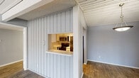 Located at 11600 Audelia Rd in Dallas, TX, this one-bedroom, one-bathroom unit offers a well-organized layout across a single floor. The living room is a standout space, featuring striking vaulted ceilings with exposed white-painted wood beams that lend an airy, open feel. A classic wood-burning fireplace with a white surround serves as the room's focal point, while durable wood-look flooring and a sliding glass door leading to a private patio complete the inviting atmosphere. Natural light flows in generously through the patio door.

The kitchen connects to the living area via a charming pass-through window framed by vertical shiplap-style paneling. White cabinetry, a full-size refrigerator, and track lighting give the kitchen a clean, functional character with light wood flooring.

The bedroom offers a comfortable, carpeted retreat with a textured ceiling, a window with blinds for natural light and privacy, and a closet with louvered bifold doors. The bathroom features a wide vanity with white cabinetry, a large mirror, and bright overhead lighting, with wood-look flooring adding a modern touch. A dedicated closet rounds out this efficient and thoughtfully designed home.