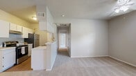 Located at 7500 Rolling Brook Dr in Frisco, TX, this 2-bedroom, 1-bathroom residence offers a practical and comfortable single-floor layout. The galley-style kitchen is well-appointed with white cabinetry, light countertops, black appliances including a range and refrigerator, a double sink, and hardwood-style flooring that adds warmth to the space. The kitchen flows naturally toward the combined living area, creating an efficient, connected layout.

Both bedrooms feature neutral carpet, ceiling fans with light fixtures, and windows that bring in natural light. The primary bedroom is generously sized, offering a dedicated closet with wire shelving, and provides direct access to the shared bathroom. The second bedroom also benefits from natural light and its own closet for added storage. A private balcony accessible from the living area extends the usable space outdoors.

The bathroom includes a walk-in shower with a curtain enclosure and hardwood-style flooring. Throughout the residence, textured ceilings, neutral wall tones, and consistent finishes contribute to a cohesive, move-in-ready aesthetic. Two closets provide ample storage to complement the well-organized floor plan.