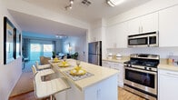 Located at 4914 Olive St in Montclair, CA, this two-story, 3-bedroom, 2-bathroom home is thoughtfully designed across two well-proportioned floors. The main level opens into a bright, modern kitchen outfitted with stainless steel appliances — including a gas range, built-in microwave, and refrigerator — complemented by crisp white cabinetry, light countertops, and wood-look flooring. A peninsula with bar seating flows seamlessly into the open-concept living room, which features plush carpeting, neutral walls, and large sliding glass doors leading to a private balcony with outdoor views. The upper floor hosts the three bedrooms, including a spacious primary suite with generous closet space featuring mirrored sliding doors and ample natural light from large windows. The additional bedrooms are well-sized and carpeted, offering comfortable retreats. Two clean, well-appointed bathrooms serve the home, one featuring a full tub-shower combination with tiled surrounds. A hallway and staircase connect the floors efficiently. Throughout, the home maintains a consistent, contemporary aesthetic with neutral tones and modern finishes, creating a bright and welcoming ambiance.