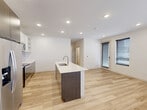 This contemporary home in Hailey, Idaho offers four bedrooms and four bathrooms across a well-designed single-floor layout. The open-concept living area seamlessly connects the kitchen, dining, and living spaces, all finished with warm light wood flooring and recessed lighting throughout. The kitchen is a standout feature, showcasing dark wood cabinetry paired with crisp white upper cabinets, a tiled backsplash, stainless steel appliances including a refrigerator, range, and microwave, and a large center island with a white quartz countertop and undermount sink. Natural light flows through multiple windows fitted with modern blinds, brightening the living area and bedrooms alike. The bedrooms are clean and functional, each offering closet space — several with sliding doors — and a neutral palette that provides a versatile canvas. With five closets total, storage is plentiful throughout the home. The four bathrooms continue the modern aesthetic, featuring wood-look flooring, dark vanity cabinetry, and fixtures in brushed nickel. One bathroom includes a tub-shower combo with a window for natural light. A dedicated laundry room adds everyday convenience, completing this well-appointed home.