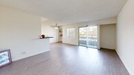 Located at 9150 Tampa Ave in Northridge, Los Angeles, this one-bedroom, two-bathroom unit offers a well-organized single-floor layout. Light wood-style flooring runs throughout, complementing the bright, neutral palette found in every room.

The galley-style kitchen features white shaker cabinetry, dark stone countertops, a classic subway tile backsplash, and a full suite of stainless steel appliances, including a refrigerator, dishwasher, range, and over-the-range microwave. An open pass-through connects the kitchen to the living area.

The spacious living room is filled with natural light from large sliding glass doors that open onto a private balcony with outdoor views. A ceiling fan adds comfort, and a dedicated window with blinds provides additional ventilation. The living area flows openly, offering flexible arrangements for furniture.

The bedroom is a comfortable size, featuring a mirrored sliding-door closet, a window with blinds, and a wall-mounted HVAC unit. Two additional closets provide generous storage throughout the unit.

Both bathrooms are finished in clean, all-white fixtures, with one featuring a full soaking tub and shower combination. The overall ambiance is bright, clean, and functional, suited for everyday living in the heart of the San Fernando Valley.