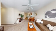 Located at 316 Columbia Dr in Carrollton, GA, this well-appointed unit offers four bedrooms and four bathrooms across a single floor, delivering a comfortable and functional layout. The living room features plush carpeting, a ceiling fan, and a bright window that fills the space with natural light, creating a welcoming atmosphere. The combined kitchen and living area is anchored by warm honey-toned cabinetry, white appliances including a refrigerator, electric range, and over-the-range microwave, along with wood-look flooring that adds a clean, contemporary feel. A dedicated laundry room houses a full-size washer and dryer with overhead wire shelving for added storage convenience. Each of the four bedrooms is carpeted and benefits from windows that invite natural light, offering a calm and comfortable retreat. The bedrooms are generously proportioned, with the primary bedroom providing ample space for furnishings and personal use. All four bathrooms feature tub-shower combinations with tiled surrounds, curtain rods, and neutral warm-toned walls, maintaining a clean and consistent aesthetic throughout. The overall color palette of soft creams and beiges lends the unit a bright, cohesive ambiance suited for comfortable everyday living.
