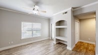 Located at 4699 Fossil Vista Dr in Haltom City, TX, this single-story one-bedroom, one-bathroom unit offers a practical and comfortable layout designed for efficient everyday living. Wood-look flooring runs throughout the entire space, lending a warm, cohesive feel to each room.

The combined kitchen and living area serves as the heart of the unit. The galley-style kitchen is equipped with warm honey-toned cabinetry, white appliances including a range, over-the-range microwave, and refrigerator, along with a countertop sink and ample storage. A built-in desk nook just off the kitchen provides a convenient workspace. The living room features crown molding, a ceiling fan, a window that brings in natural light, a sliding door to the exterior, and a distinctive arched built-in shelving unit that adds architectural character.

The bedroom is a comfortable, well-lit space with a ceiling fan, a window overlooking the outdoors, and access to a dedicated closet. Six-panel doors throughout add a clean, classic touch to the interior.

The bathroom features a full tub-shower combination with white tile surround, chrome fixtures, and wood-look flooring that ties the space together. A private backyard with a grassy area and fencing is also accessible from the unit, offering a pleasant outdoor retreat.