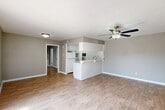 Located at 2530 Briar Ridge Dr in Houston, TX, this single-story, one-bedroom, two-bathroom home offers a well-organized layout with consistent wood-look flooring and a neutral gray color palette throughout. The open living and dining area is bright and airy, anchored by a ceiling fan and a sliding glass door that invites natural light and provides access to an outdoor patio. The kitchen features white cabinetry, a white refrigerator, and a pass-through breakfast bar that connects seamlessly to the dining and living spaces, making the layout feel open and cohesive. The spacious primary bedroom is equipped with its own ceiling fan, a dedicated closet, and a built-in vanity with drawers and a mirror, offering both comfort and practical storage. Two full bathrooms serve the home; one includes a white vanity with a marble-style countertop and a full tub-shower combination. An additional room with built-in shelving provides flexible space for a home office or secondary living area. Two closets offer ample storage. Textured ceilings are found throughout, adding a subtle architectural detail. The home's clean, functional design makes it a practical and comfortable residence in a Houston neighborhood.