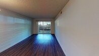 Located at 2949 Portage Bay W in Davis, California, this single-floor apartment offers a well-organized layout designed for comfortable everyday living. The living and dining areas are finished with rich, dark hardwood flooring that extends throughout the main spaces, creating a cohesive and polished look. A pendant light fixture accents the dining area, while a sliding glass door opens to a private outdoor patio, allowing natural light to fill the room and providing a direct connection to the outdoors. The open layout of these shared spaces makes the unit feel airy and functional.

The kitchen is equipped with white cabinetry, a white range, and granite-style countertops, offering a clean and practical workspace. Adjacent to the kitchen, the bathroom features matching granite-look countertops at the vanity, dark hardwood flooring, and a full soaking tub and shower combo with tiled surround walls, adding a touch of comfort and utility.

The bedroom is carpeted for warmth and comfort, with a window that frames views of mature trees outside, bringing a sense of nature into the private space. A sliding-door closet provides organized storage with a full-width hanging rod and shelf. Textured ceilings are present throughout the unit, consistent with the building's architectural character.