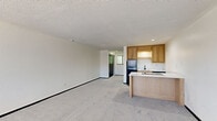 Located at 4336 Mission Rd in Kansas City, KS, this single-floor studio offers a practical and efficient layout across a compact footprint. The open living area is finished with neutral-toned carpet and crisp white walls beneath a textured ceiling, creating a clean, understated aesthetic throughout.

The kitchen is a standout feature, thoughtfully designed with light wood cabinetry, a white countertop peninsula that doubles as a workspace or casual dining area, and an electric cooktop built into the island surface. A black refrigerator, a sink with under-cabinet storage, and a dishwasher complete the functional lineup. Tile flooring in the kitchen adds a practical contrast to the carpeted living space.

The bathroom is fitted with a full-size tub and shower combination in a clean white surround, complemented by tile flooring that ties in with the kitchen. A dedicated closet provides additional storage. Recessed lighting in the kitchen adds a modern touch, while the overall neutral palette keeps the space feeling bright and open. This studio is a well-organized unit well-suited for those seeking a straightforward and manageable living space in Kansas City.